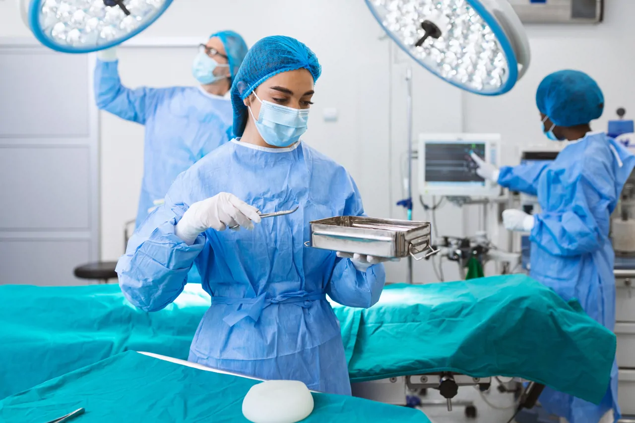 Theatre nurse preparing surgical instruments in a hospital operating room