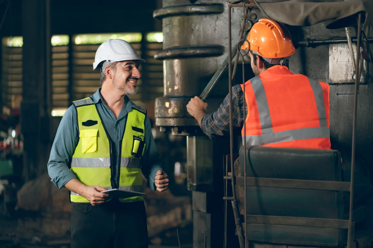 Two people working on mechanical equipment