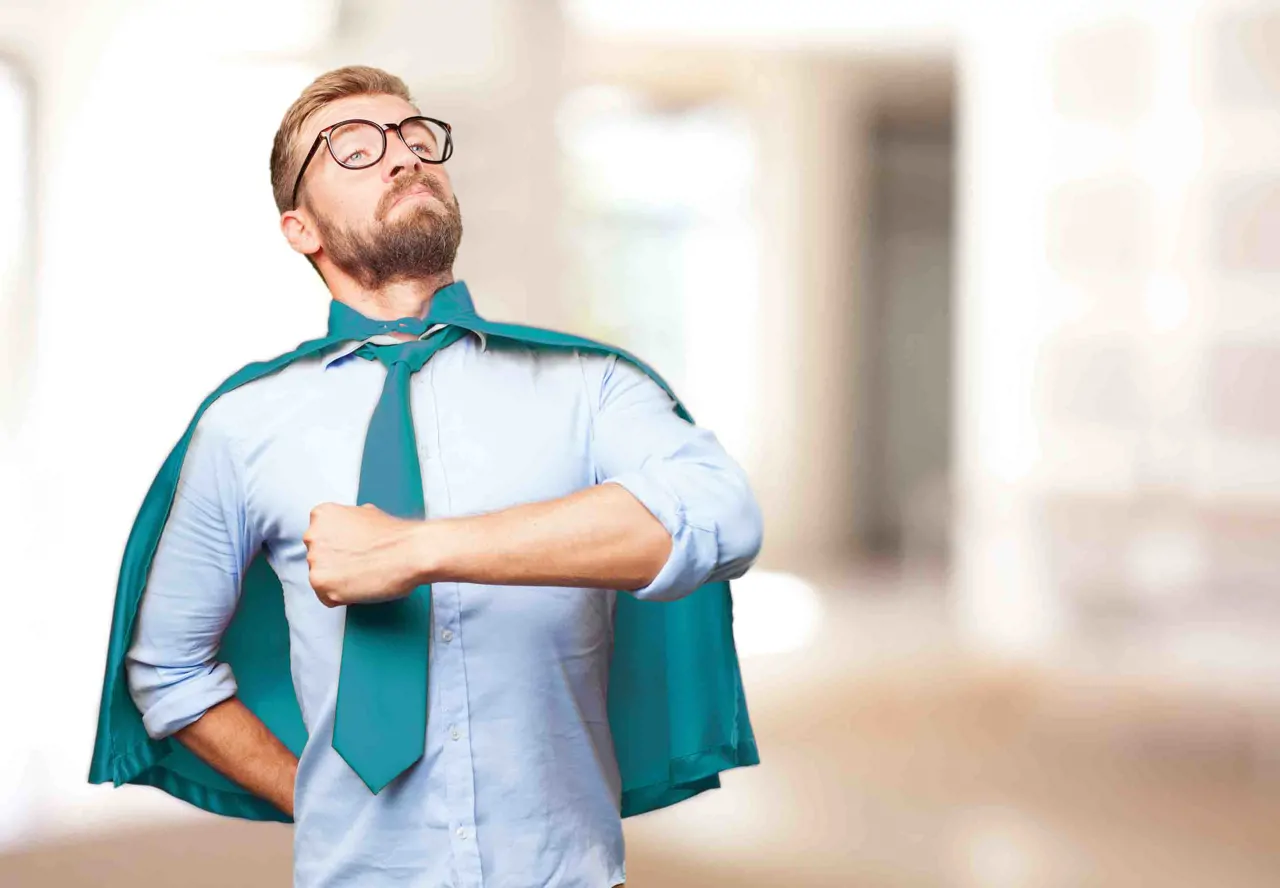 A man in business clothing with a teal cape