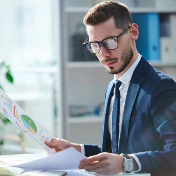 Professional in finance reviewing paper reports and planning future investments
