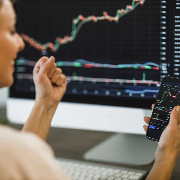 FinTech analyst reviewing real-time market data on multiple screens