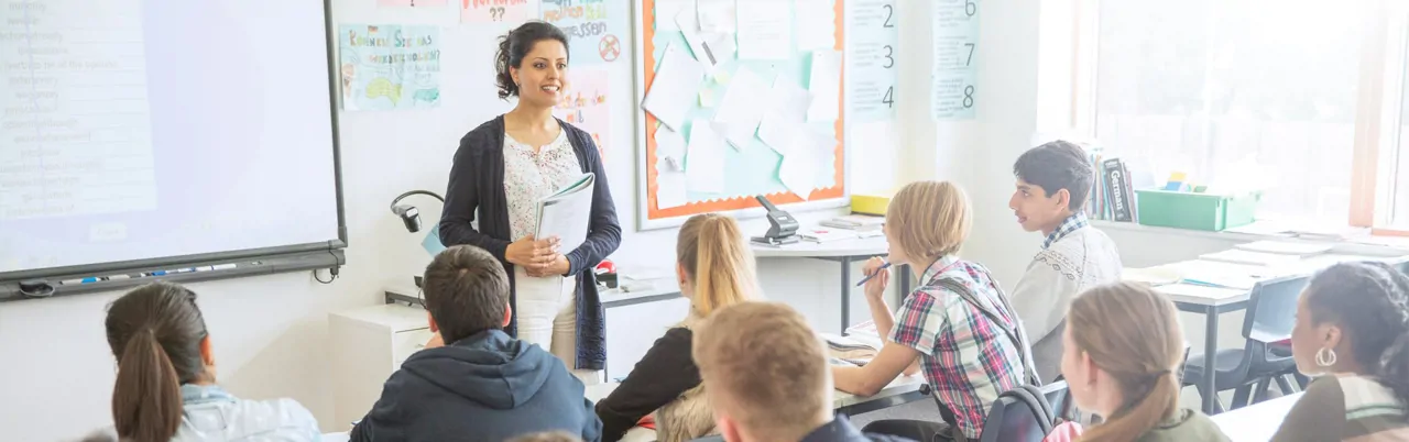 A female teacher standing in front of a class of older students