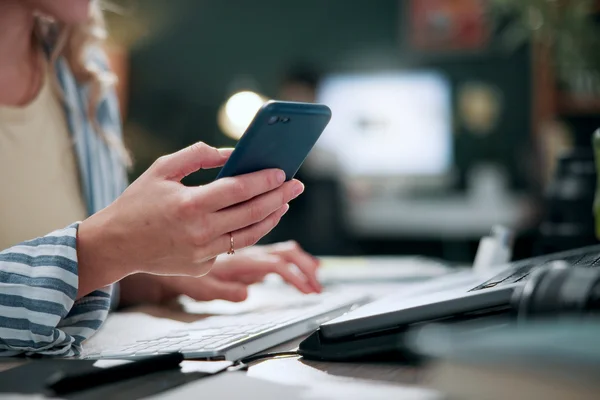 Woman Scrolling on mobile in office checking company profile