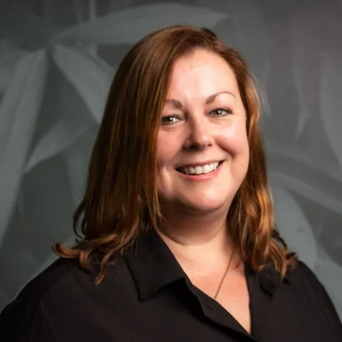 Headshot of Meridian's Finance Director with a pattered backdrop