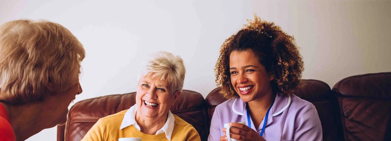 A nurse smiling with two ladies