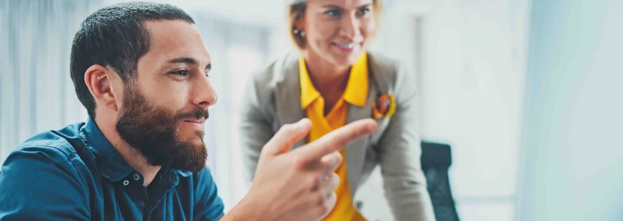 Work colleagues smiling while having a discussion in the office