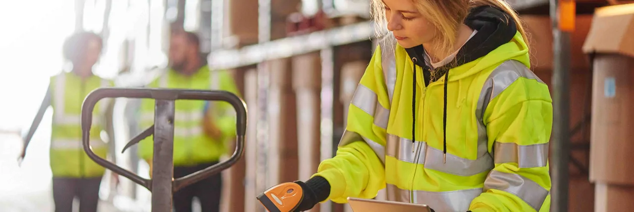 A female warehouse operative scanning boxes