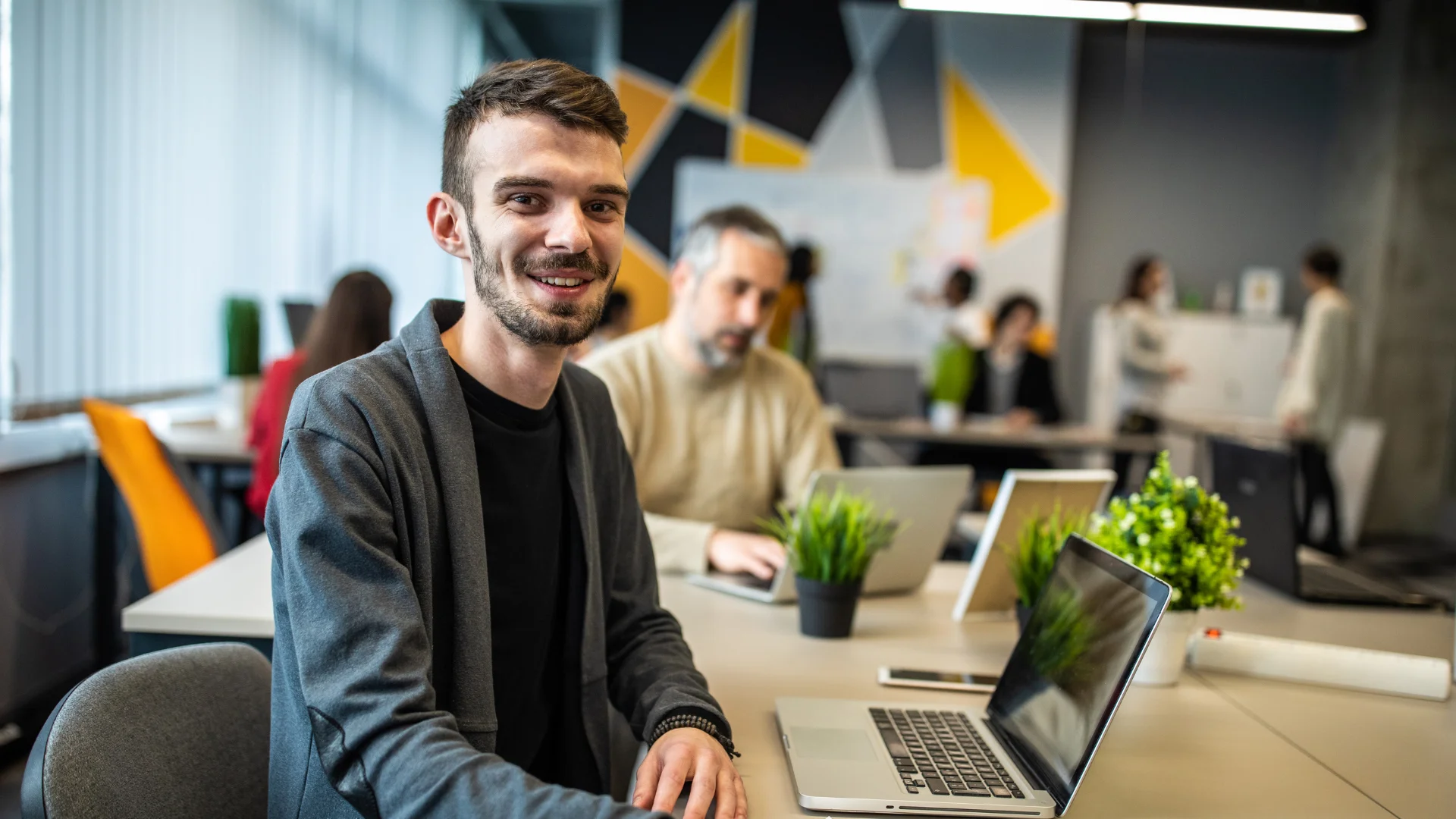 Administrative staff working at a laptop in open plan office