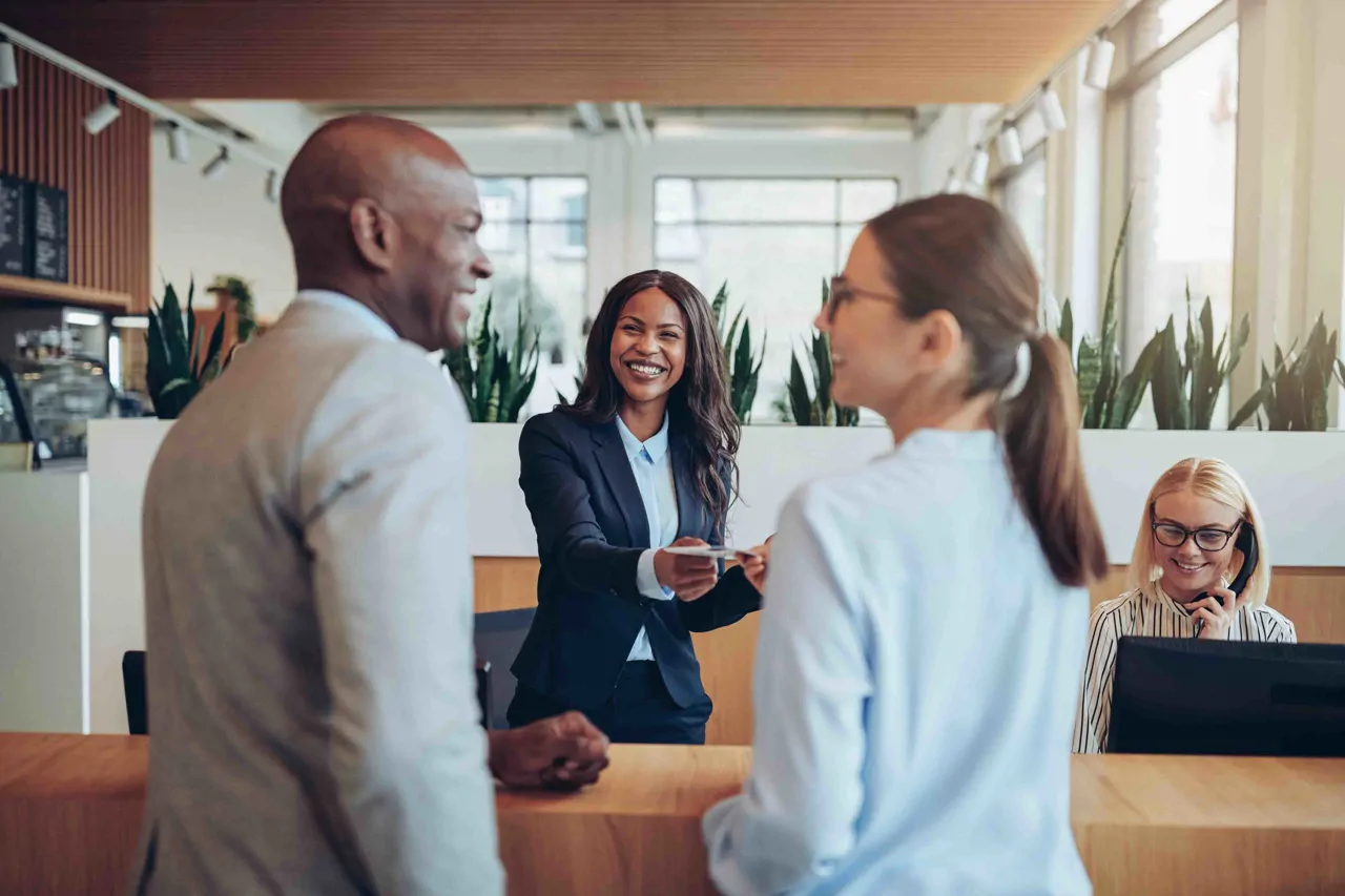 Hotel concierge greeting two guests