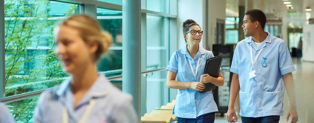 Three healthcare professionals walking down corridor