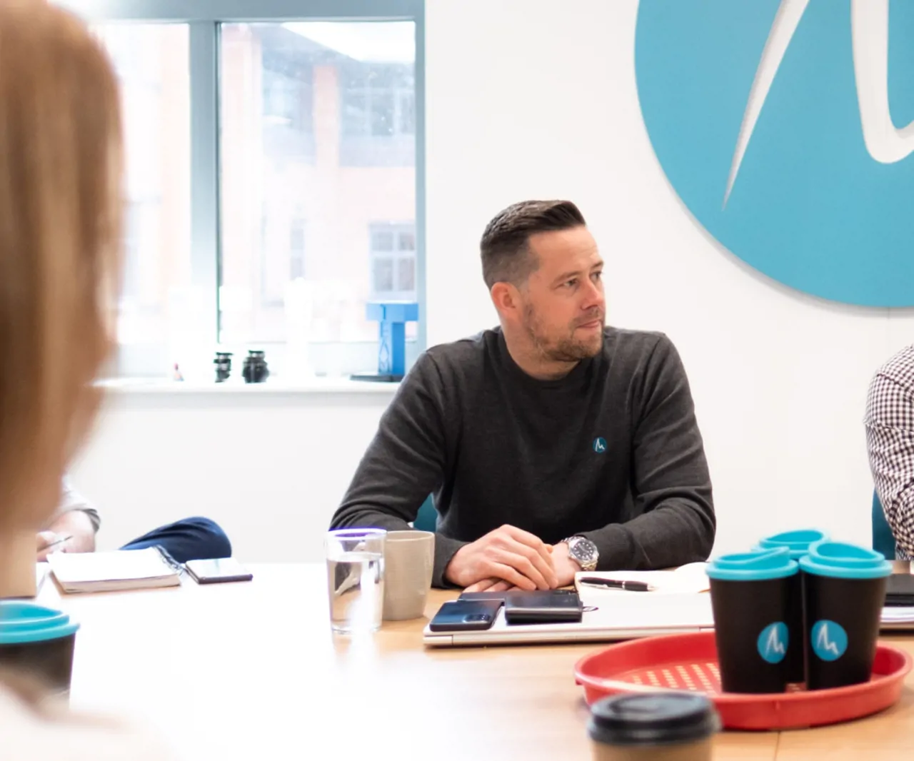 Senior operations director in board meeting at head office with Meridian signage on the wall behind