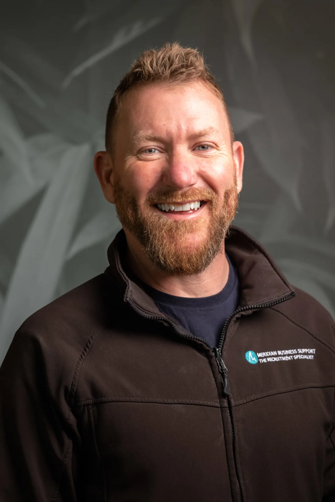 Man with beard smiling for headshot photo