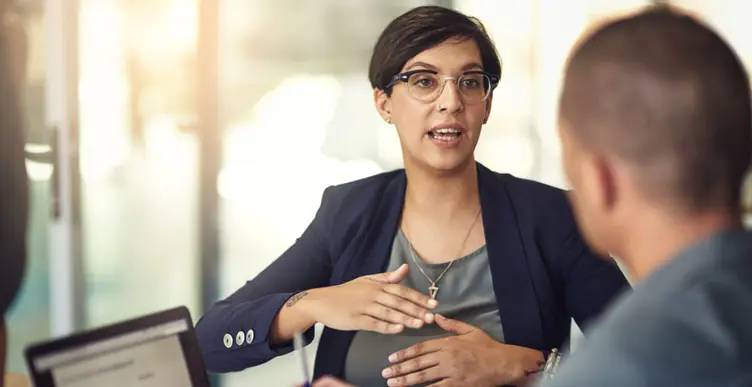 A person in a suit talking to a group of peopleAI-generated content may be incorrect.