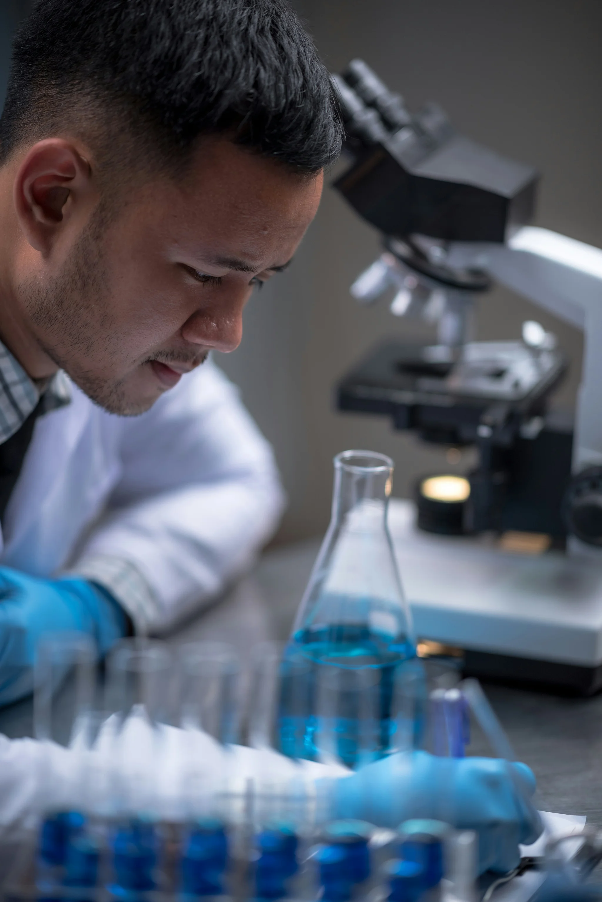 Man in lab looking at a large flask