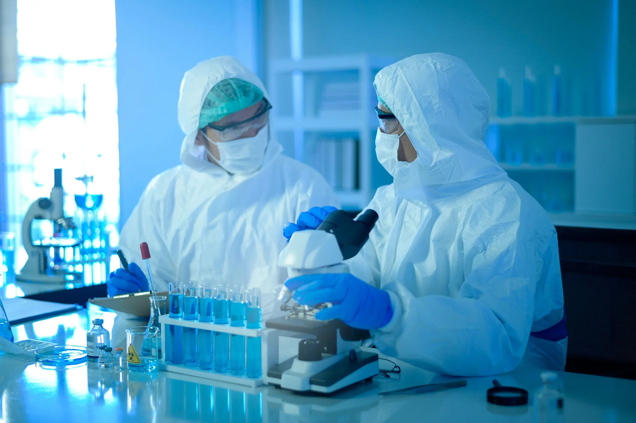 men in lab suits and masks experimenting