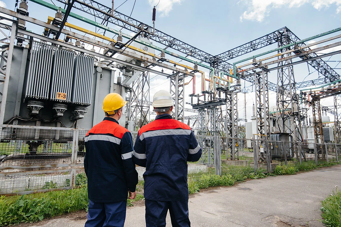 men outside an electrical substation