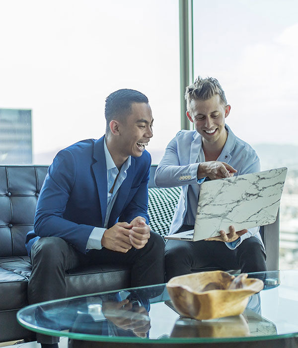 male graduates discuss on laptop