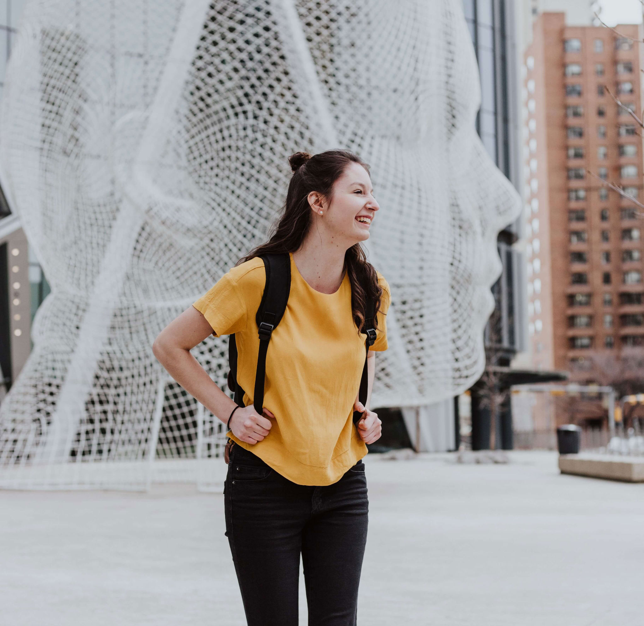 female graduate in front of sculpture 