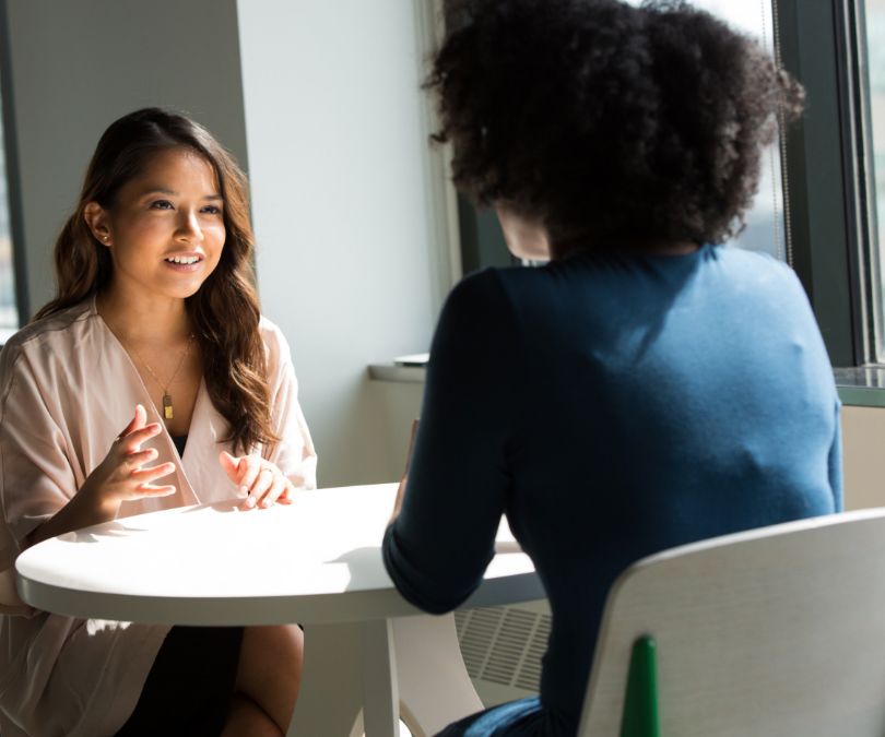 2 females discuss face to face 