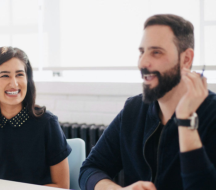 man and woman laughing in the office