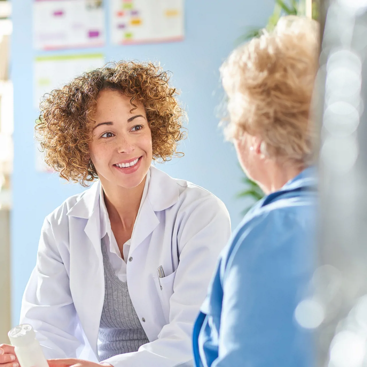 Pharmacy dispenser talking to patient