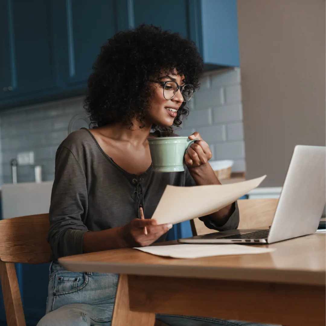 woman drinking coffee fixing her resume