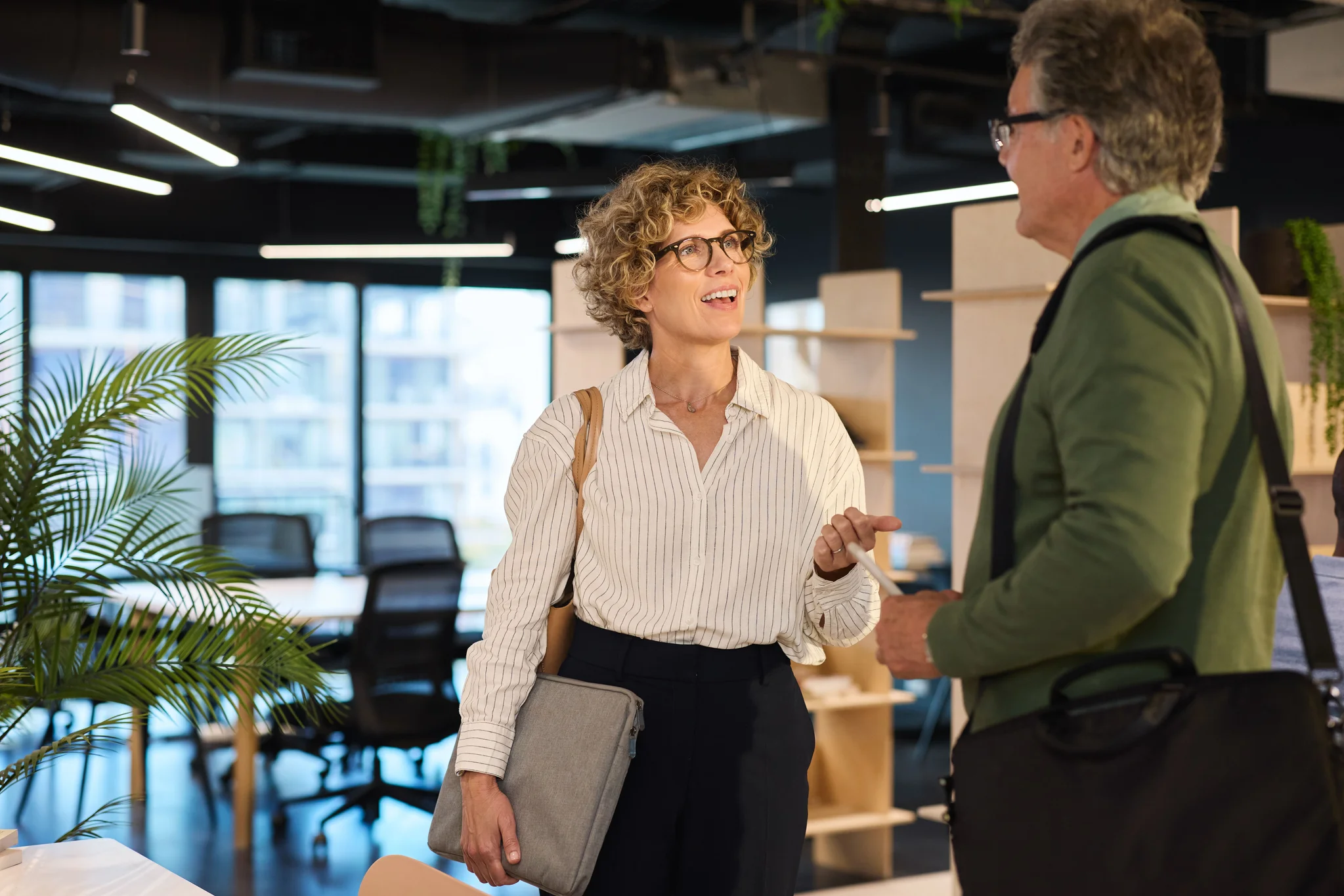 A woman with glasses speaking to man