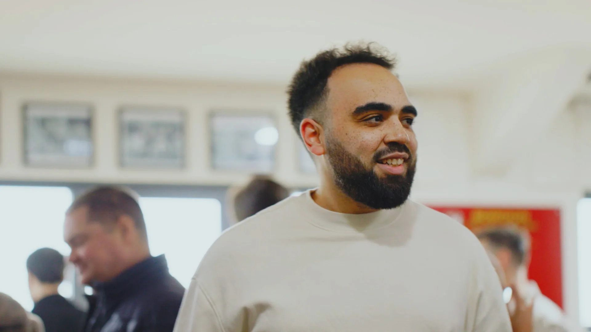man in white jumper smiling