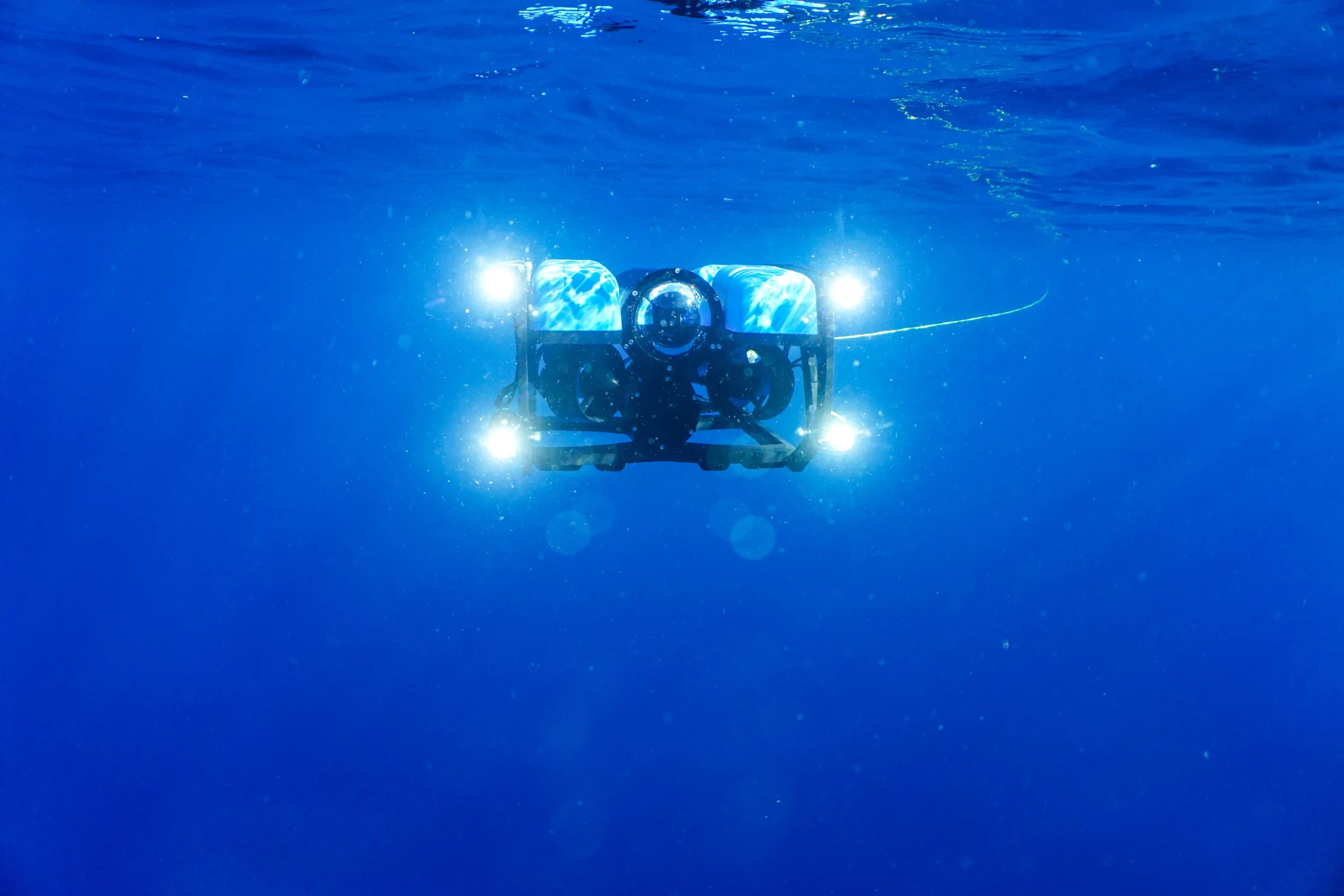 ROV with lights on submerging into water