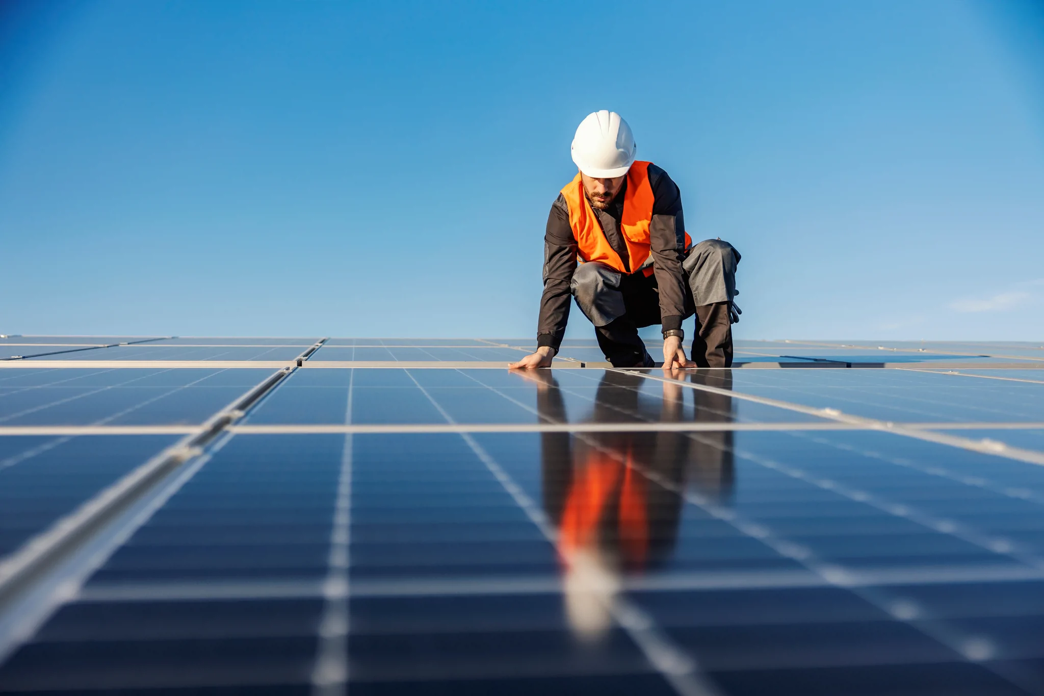 man on solar panel fixing together