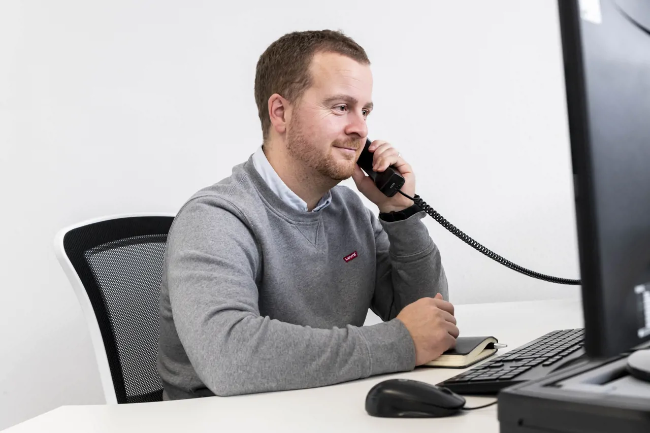 Mike Hoyle sat at a desk on a phone