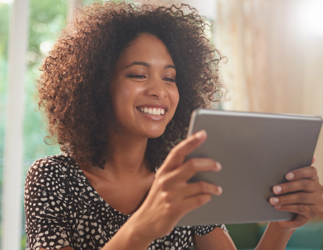 A young woman smiling at a touch screen device