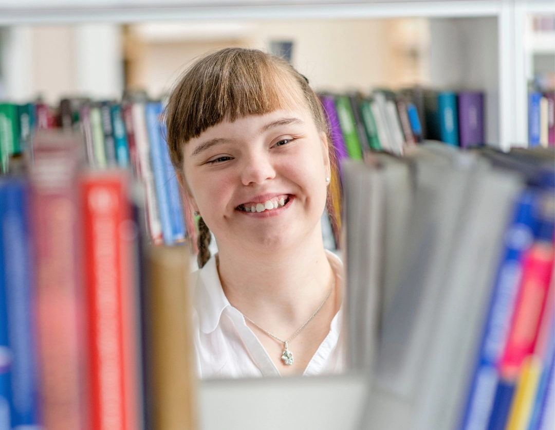 A young girl smiling in a library