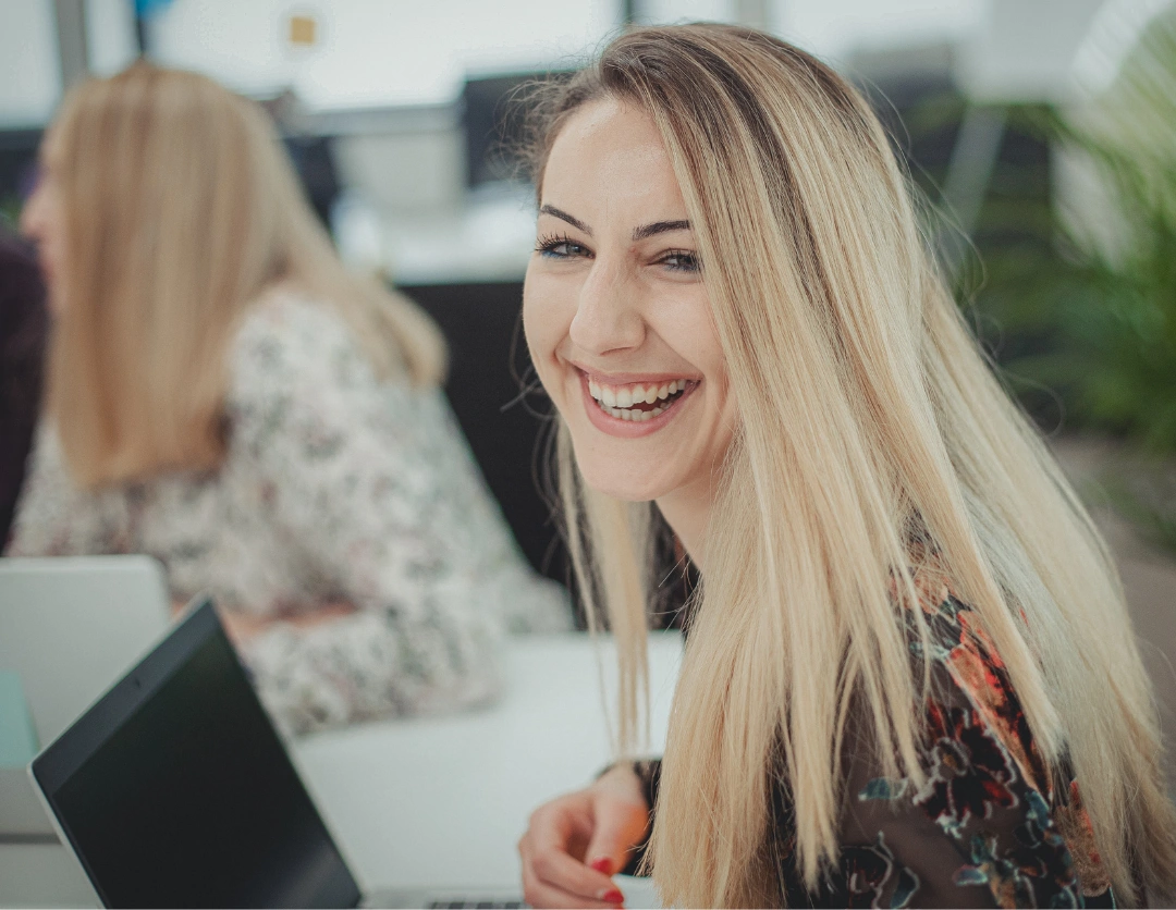 A young women sat in front of a laptop