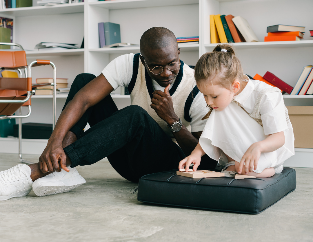 A man helping a young girl complete a puzzle