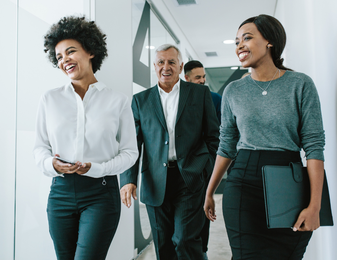 Four colleagues walking and smiling