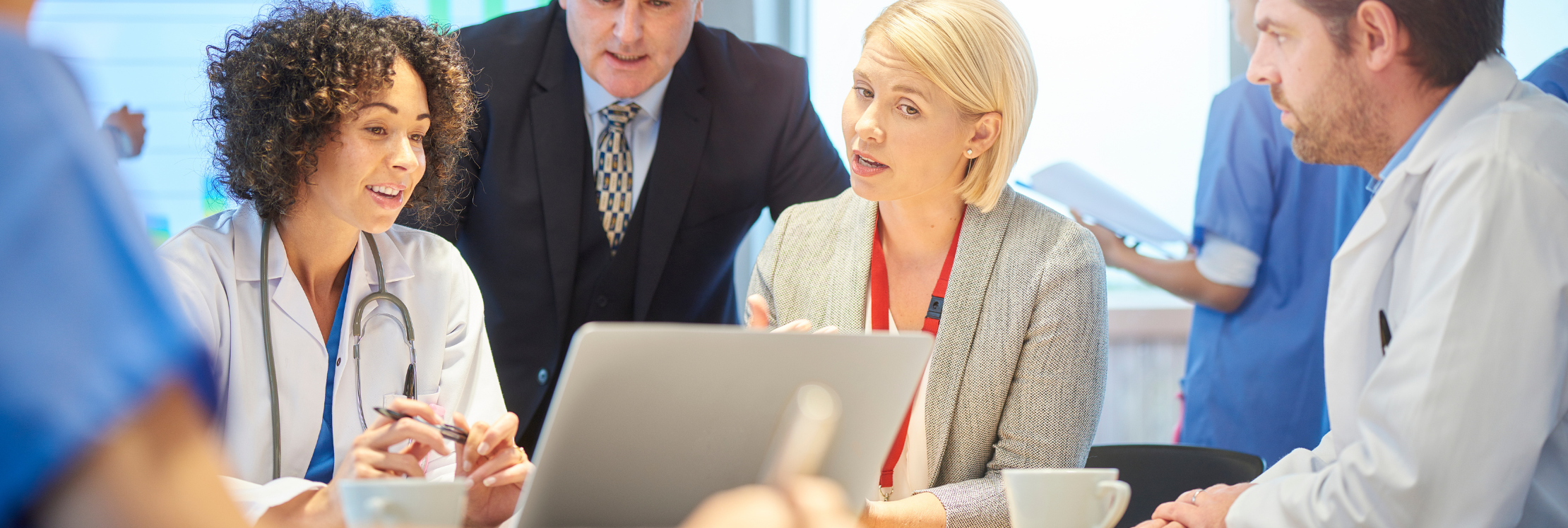 A group of healthcare professionals sat at a desk in front of a laptop