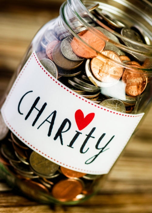A jar of coins with 'charity' on the label