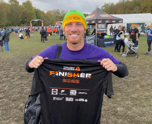 Adam Pickering holding a Tough Mudder T-shirt