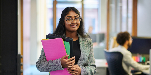 Female in an office holding a clipboard