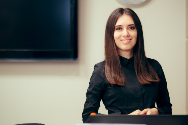 A young women smiling in front of a computer