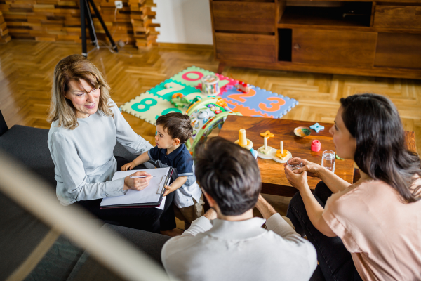 A professional sat speaking with a young family 