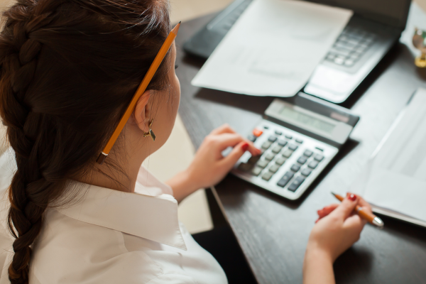 A woman typing into a calculator