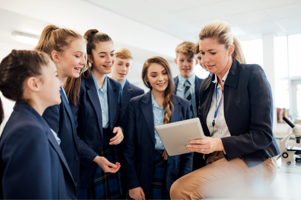 A teaching professional stood with pupils.