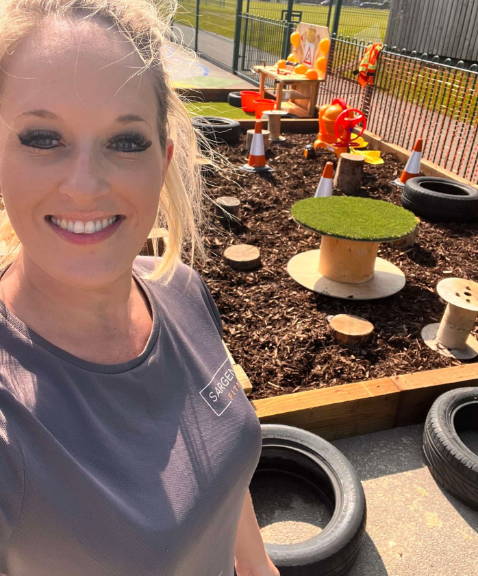 A Spencer Clarke Group employee with a playground they helped to build in the background