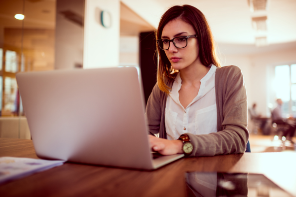 A lady sat at a desk working on her laptop