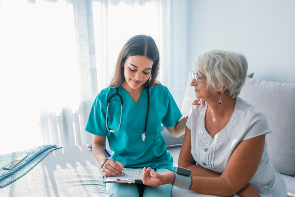 A female nursing professional sitting with a female patient