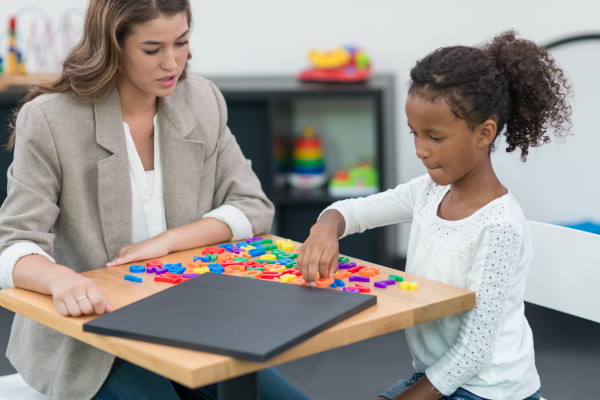 A female Occupational Therapist helping a little girl