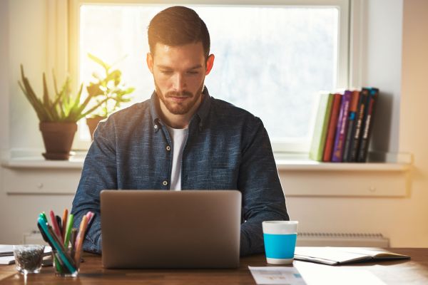 A man sat looking at a laptop