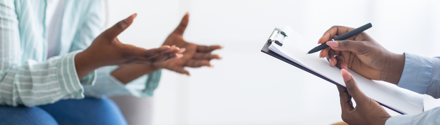 A ladies hands out stretched and another pair of hands writing on a clipboard